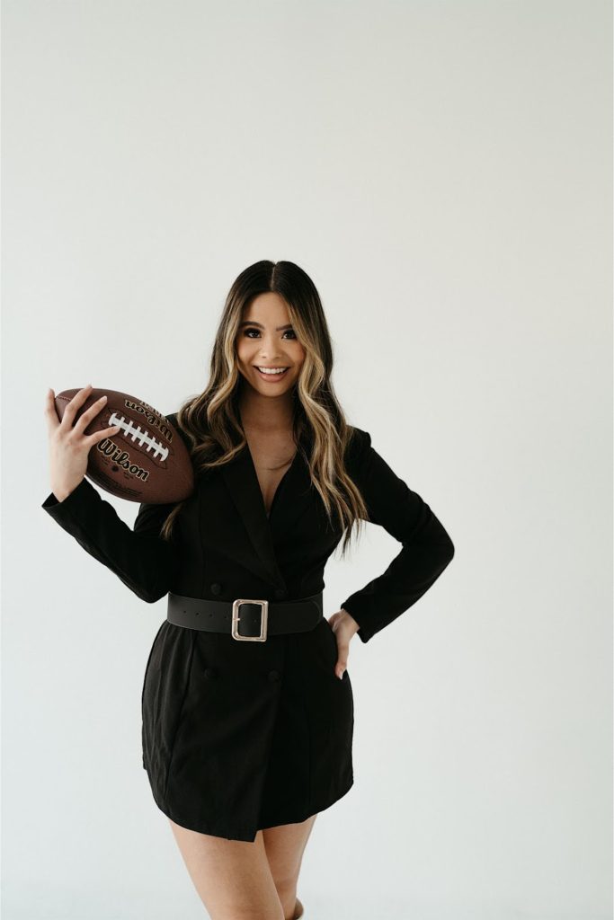 Minty in black dress holding football