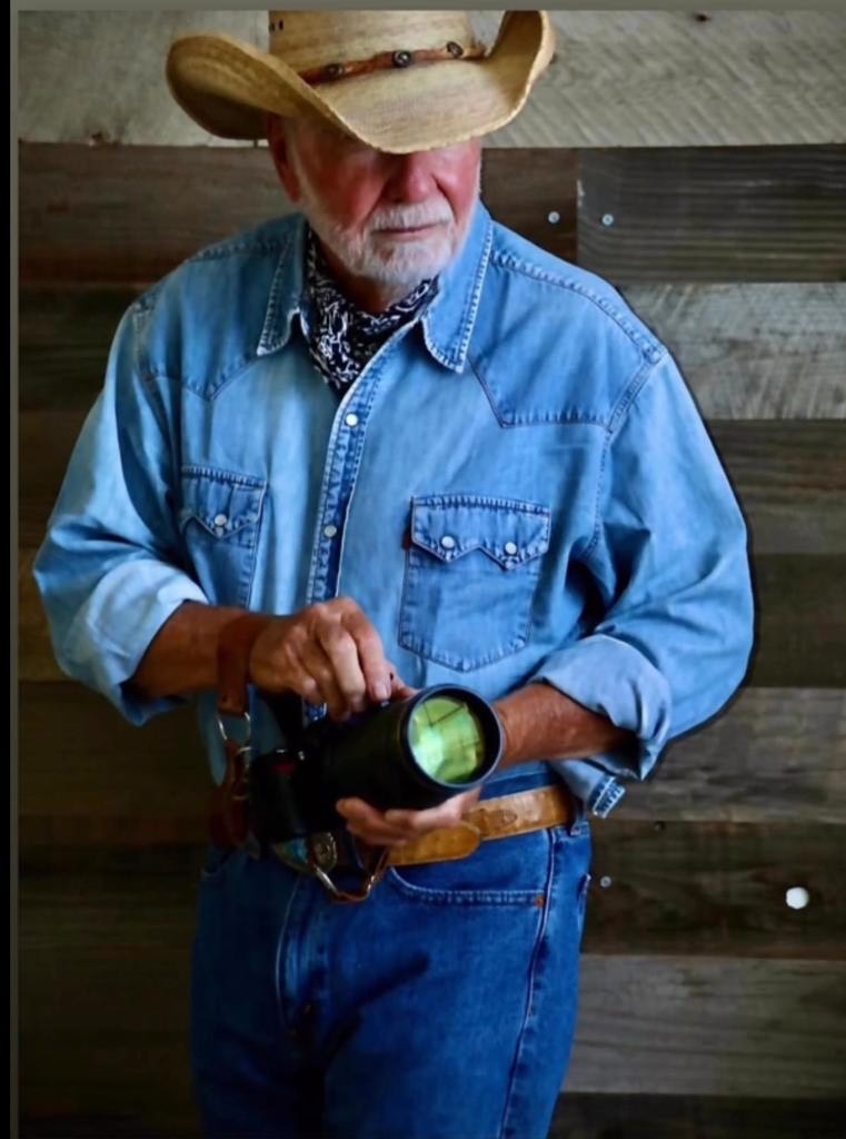 Stephen Wayda in a denim shirt holding his camera