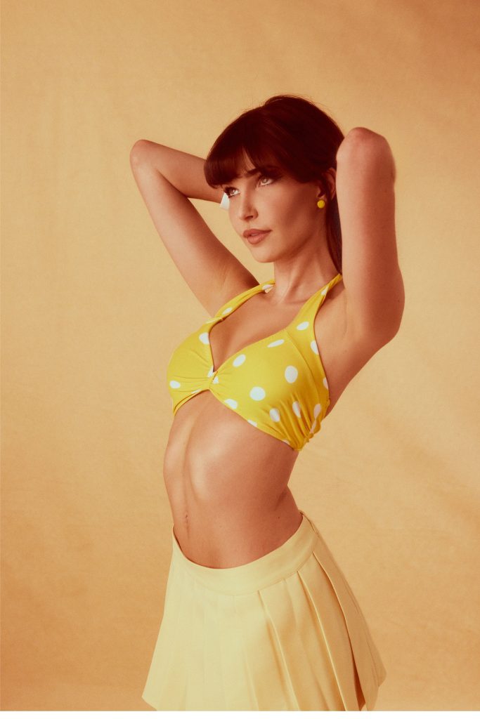 Charlotte D'Alessio wearing a yellow bra top and matching skirt